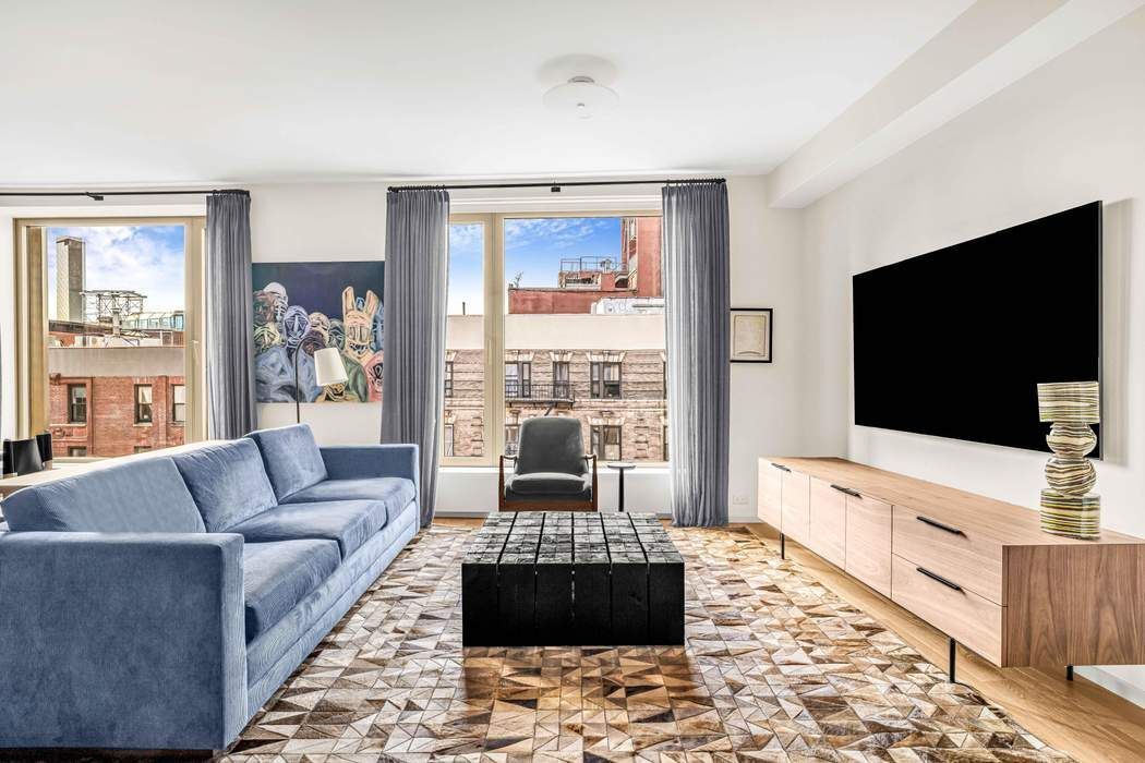 75 Kenmare Street, Unit 6B Manhattan, NY 10012 - Photo 2 of 11 a living room with furniture and a flat screen tv