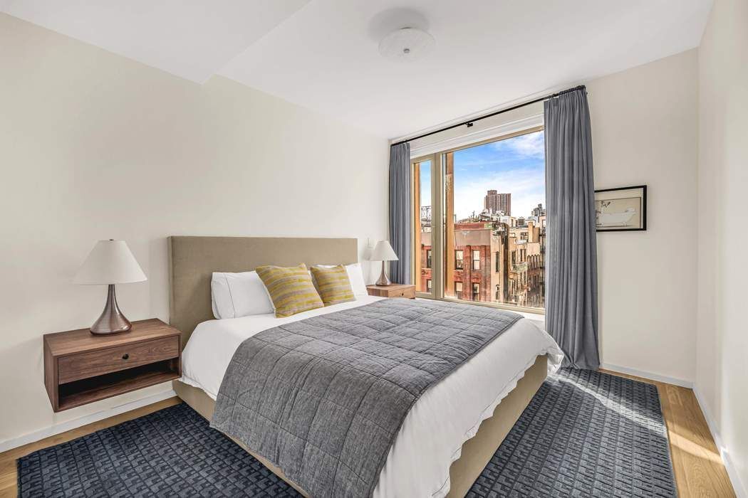 75 Kenmare Street, Unit 6B Manhattan, NY 10012 - Photo 8 of 11 a bedroom with a bed and a mirror