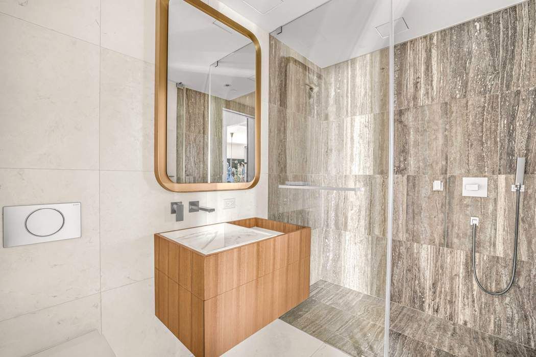 75 Kenmare Street, Unit 6B Manhattan, NY 10012 - Photo 9 of 11 a bathroom with a sink and a mirror