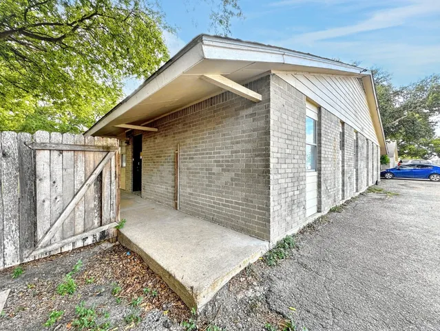 a view of a house with a small yard and wooden fence
