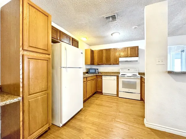 a kitchen with cabinets stainless steel appliances and a window