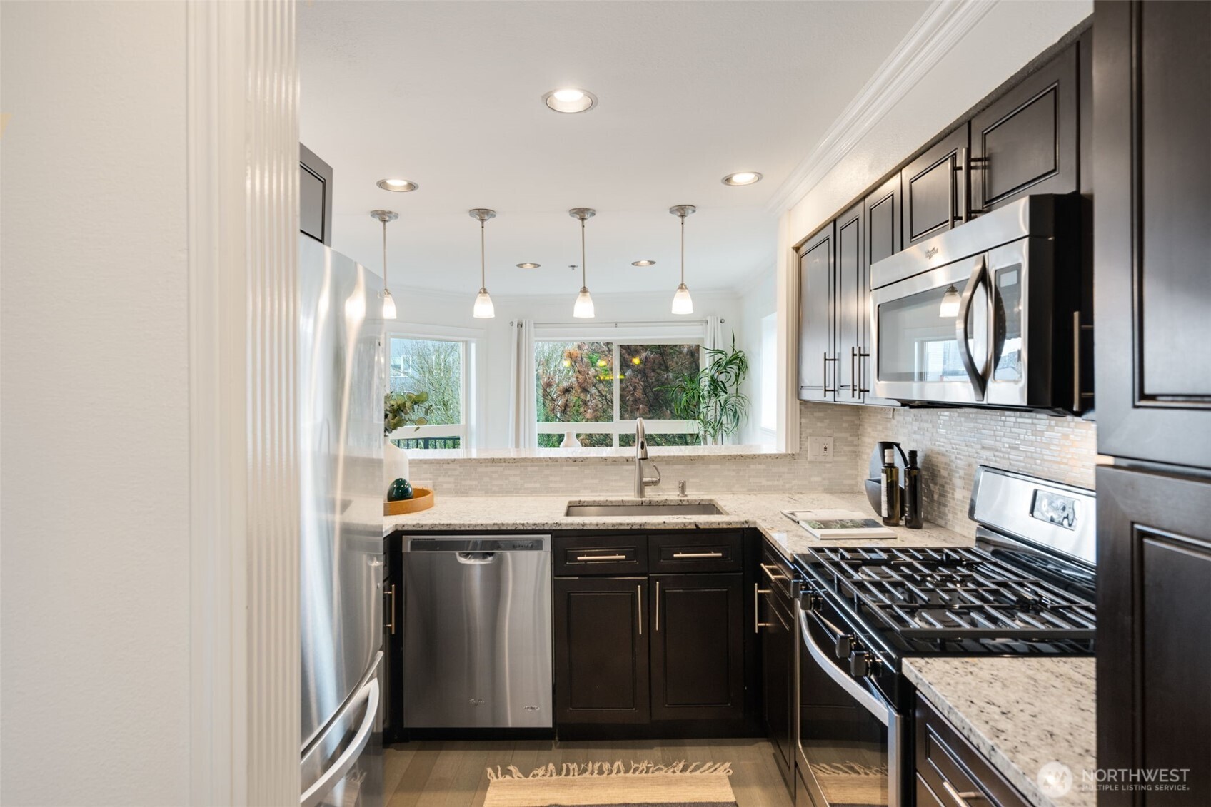 701 Galer Street, Unit 819 Seattle, WA 98109 - Photo 8 of 21 a kitchen with stainless steel appliances granite countertop a sink stove and cabinets