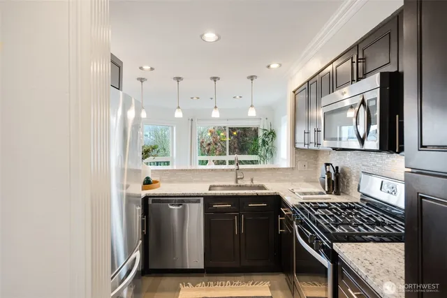 a kitchen with stainless steel appliances granite countertop a sink stove and cabinets