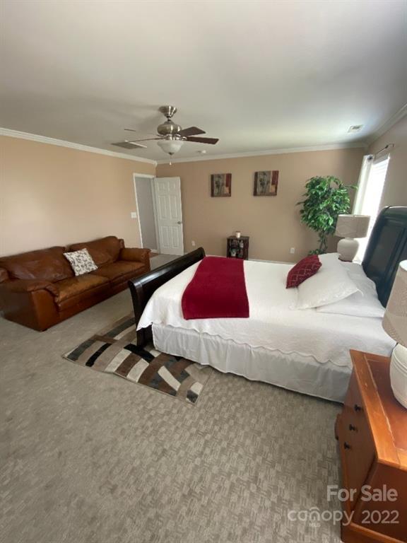 12014 Downy Birch Road, Unit 436 Charlotte, NC 28227 - Photo 20 of 26 a bedroom with a bed a couch and potted plant on the dresser