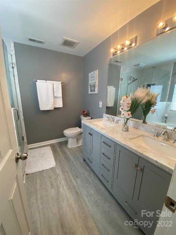 12014 Downy Birch Road, Unit 436 Charlotte, NC 28227 - Photo 23 of 26 a bathroom with a double vanity sink toilet and mirror