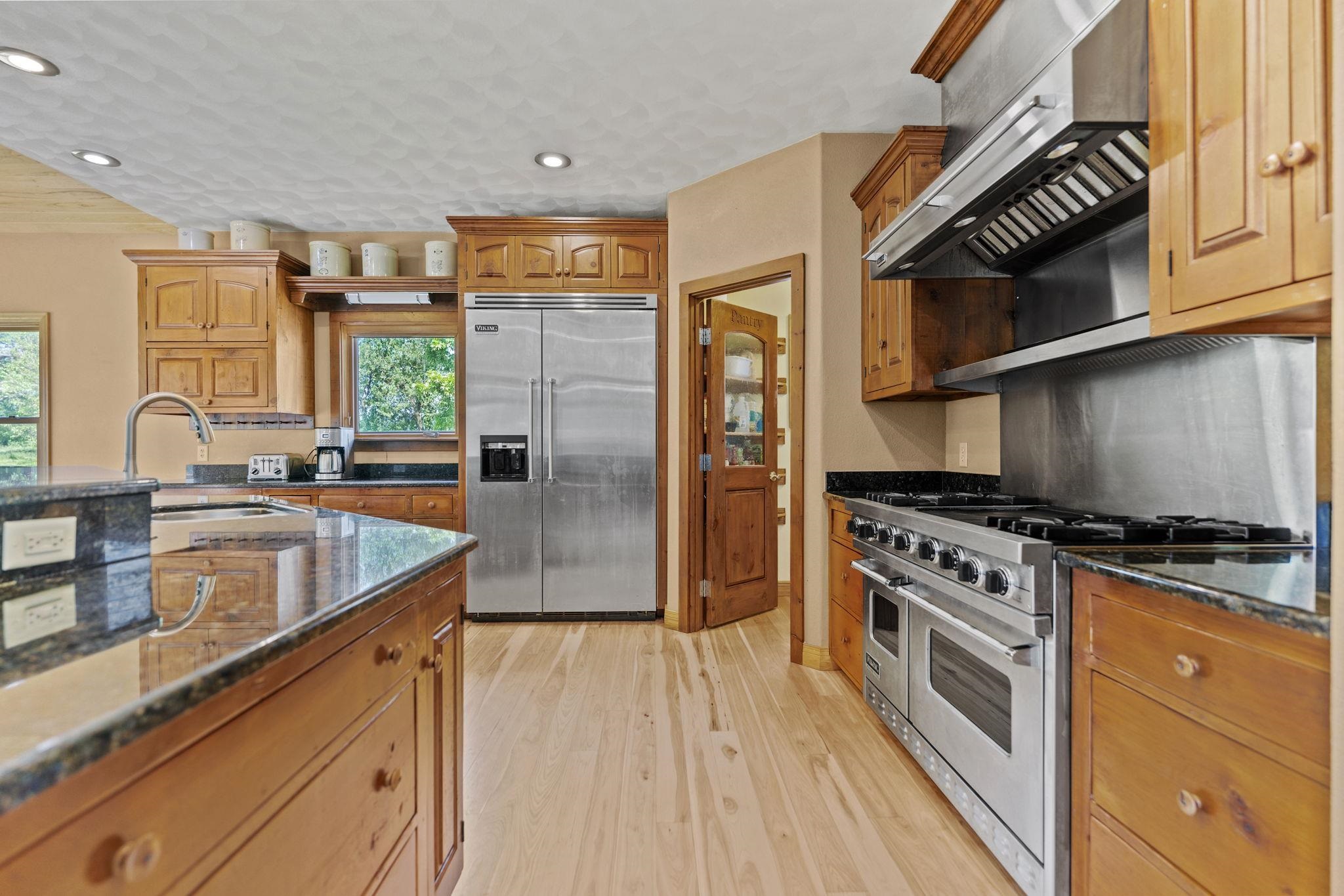 12830 Beloit Road Caledonia, IL 61011 - Photo 15 of 52 a kitchen with stainless steel appliances granite countertop a stove a sink and a refrigerator
