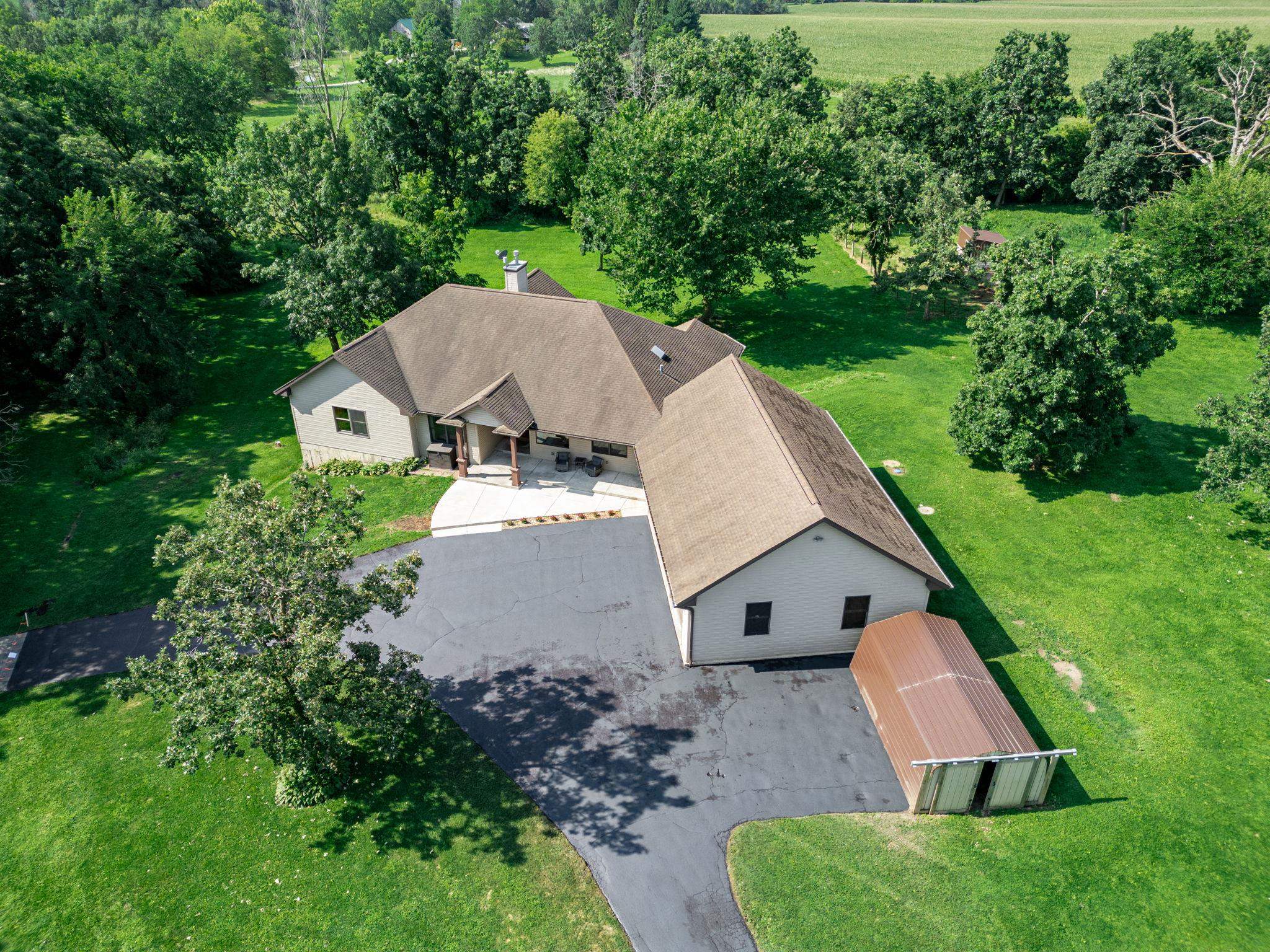 12830 Beloit Road Caledonia, IL 61011 - Photo 2 of 52 an aerial view of a house with yard and trees in the background
