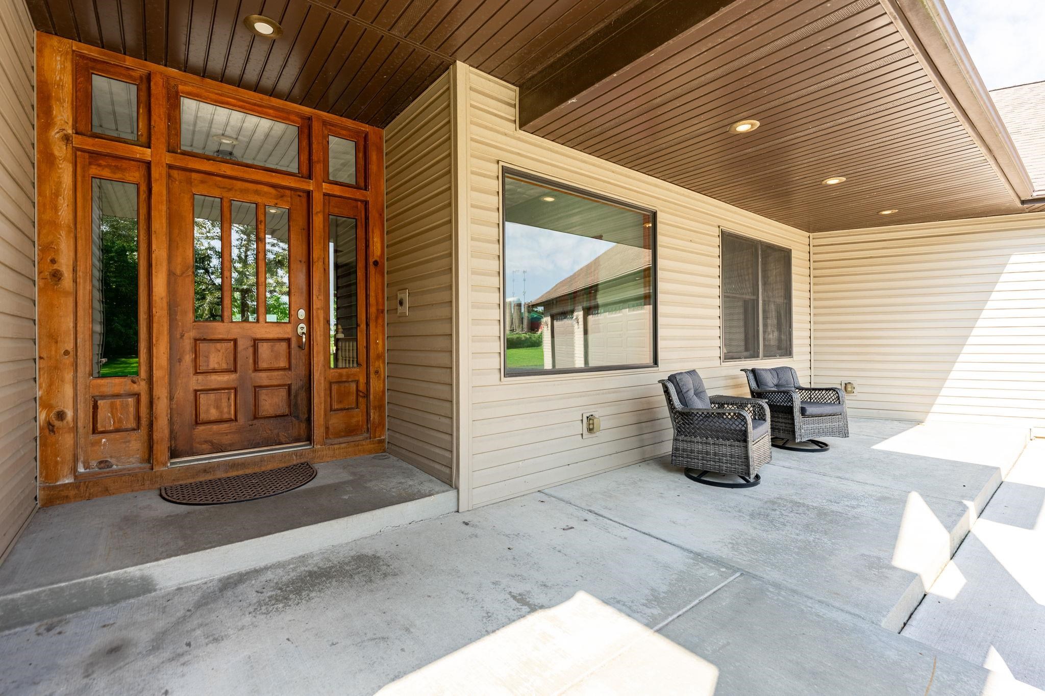12830 Beloit Road Caledonia, IL 61011 - Photo 8 of 52 a view of a patio with table and chairs and wooden fence