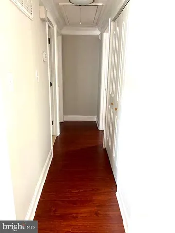 a view of a hallway with wooden floor