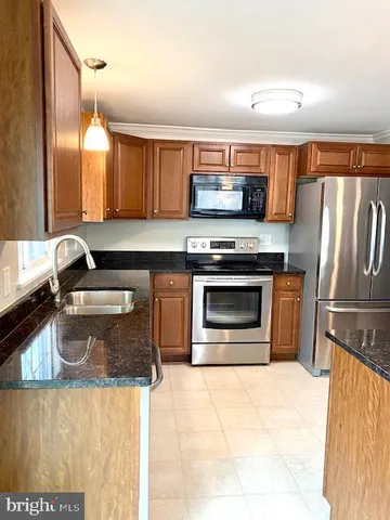 a kitchen with stainless steel appliances granite countertop a stove a sink and a refrigerator