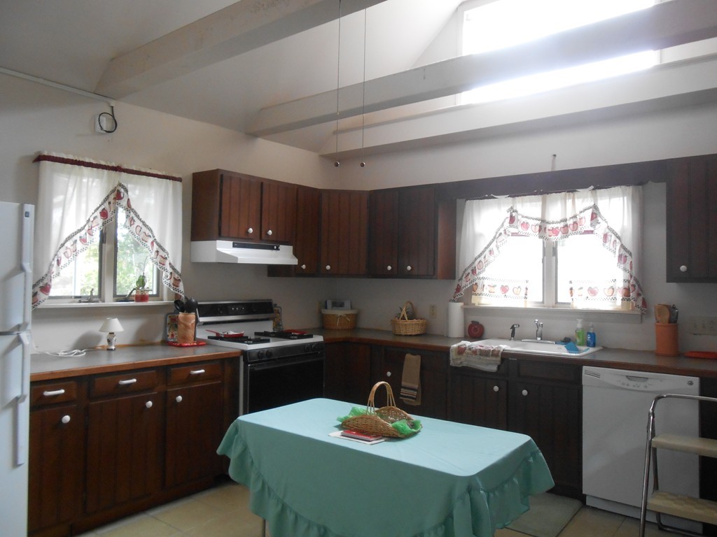 777 New Boston Road Fall River, MA 02720 - Photo 3 of 13 a kitchen with a sink a stove a refrigerator a kitchen island and chairs