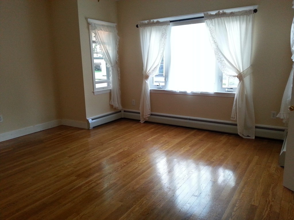 777 New Boston Road Fall River, MA 02720 - Photo 4 of 13 an empty room with wooden floor and windows