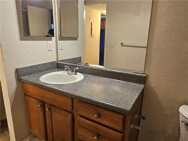a bathroom with a granite countertop sink and a mirror
