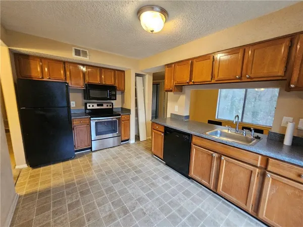 a kitchen with stainless steel appliances granite countertop a refrigerator and a sink
