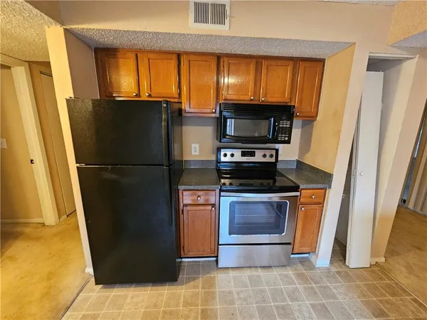 a kitchen with stainless steel appliances granite countertop a stove a sink and a refrigerator