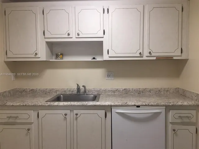 a kitchen with white cabinets and a sink