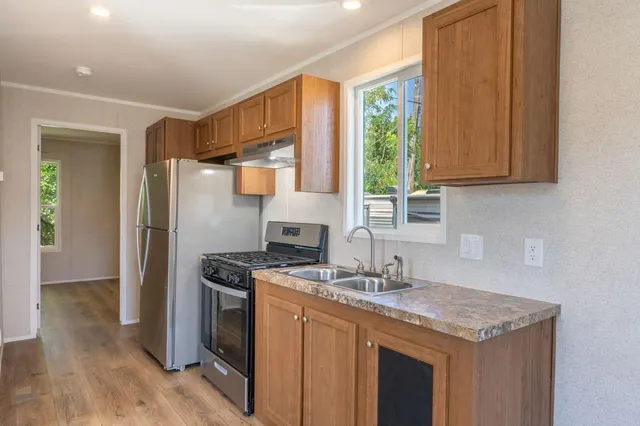 a kitchen with stainless steel appliances granite countertop a sink stove and refrigerator
