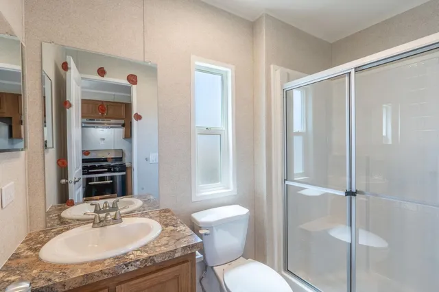 a bathroom with a granite countertop sink toilet and shower