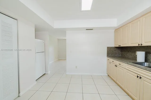 a kitchen with granite countertop white cabinets and appliances