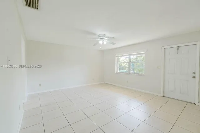an empty room with windows and fan