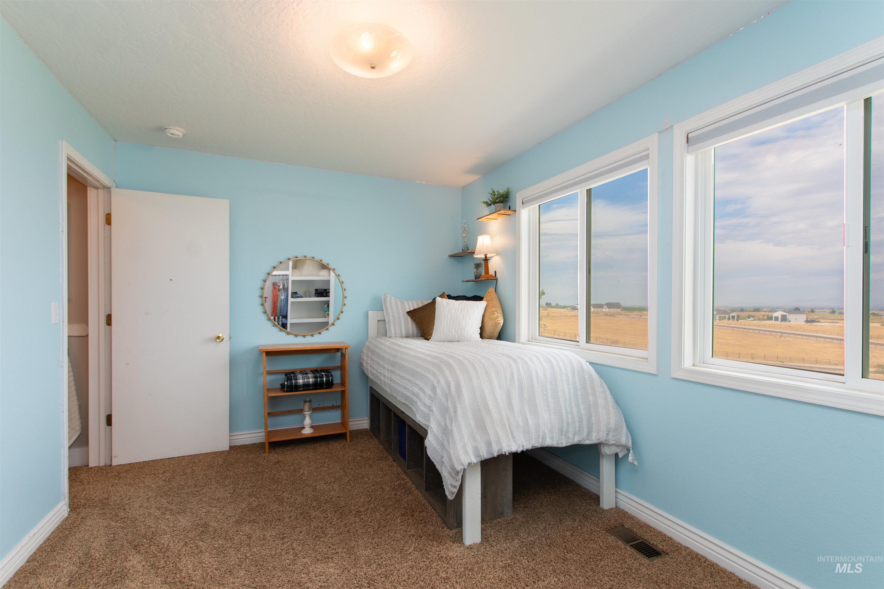 12369 Deer Flat Road Nampa, ID 83686 - Photo 37 of 50 Expansive covered porch featuring wood flooring, white railings, and exterior wall sconces