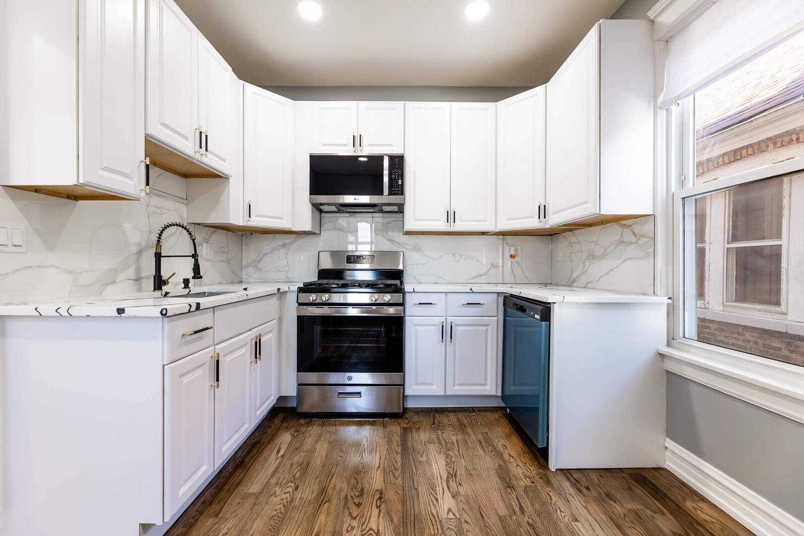 8817 South Morgan Street Chicago, IL 60620 - Photo 11 of 37 a kitchen with stainless steel appliances granite countertop a sink a stove a microwave and cabinets