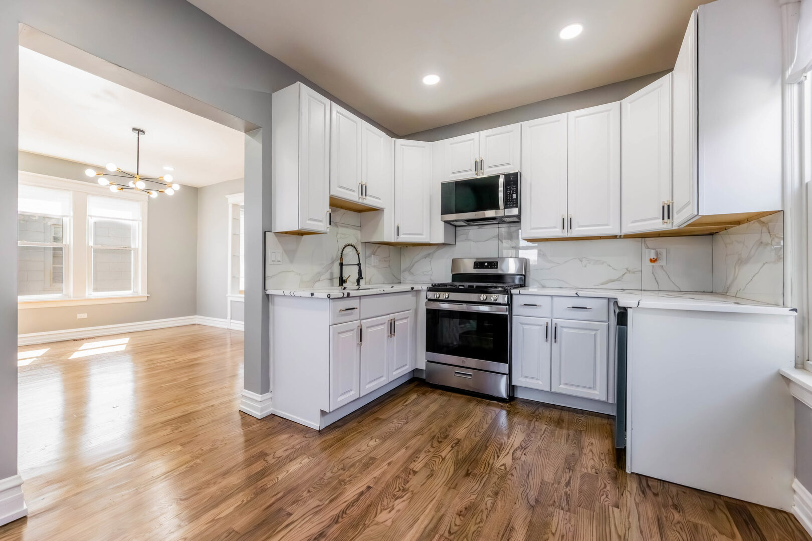8817 South Morgan Street Chicago, IL 60620 - Photo 10 of 37 a kitchen with granite countertop white cabinets and white appliances