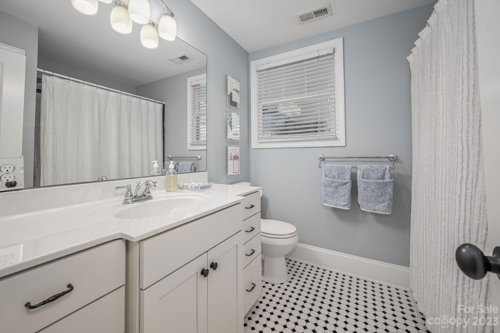 1001 Sedgefield Road Charlotte, NC 28209 - Photo 20 of 30 a bathroom with a sink a toilet a mirror and shower