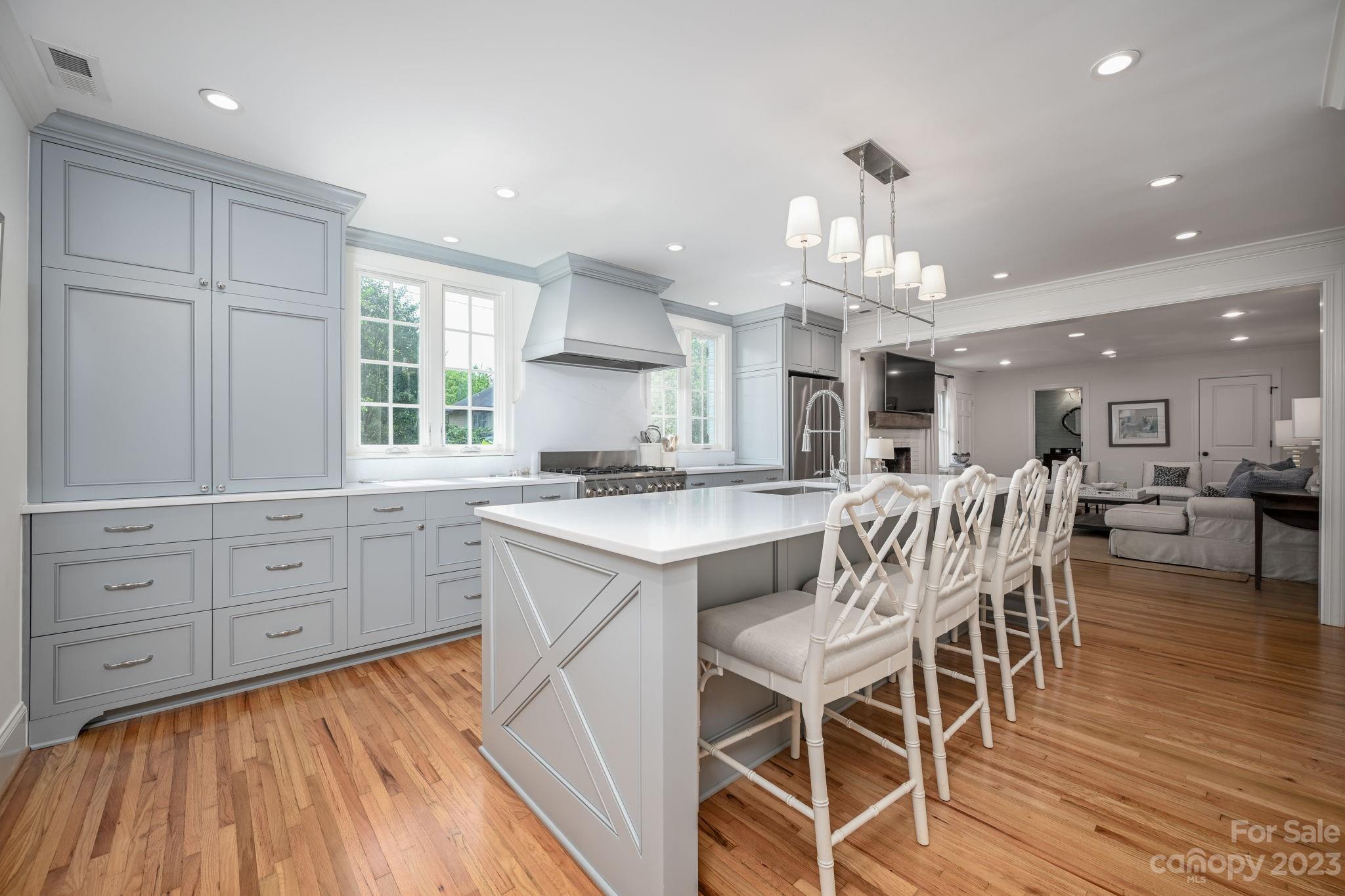 1001 Sedgefield Road Charlotte, NC 28209 - Photo 6 of 30 a kitchen with a dining table chairs wooden floor cabinets and a large window