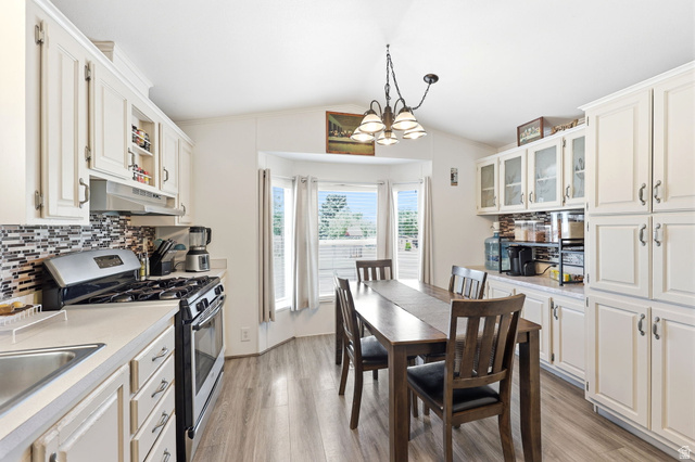 1525 South 400 East, Unit 13 Springville, UT 84663 - Photo 13 of 32 Kitchen featuring ample white cabinetry, a tiled backsplash, and wood-finish flooring