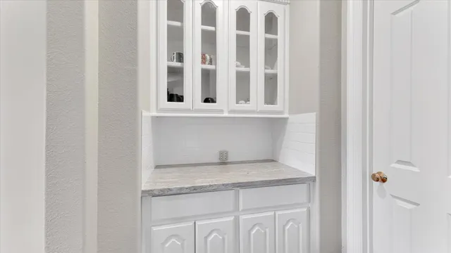 a kitchen with granite countertop white cabinets and a window