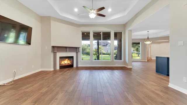 a view of an empty room with wooden floor and a fireplace