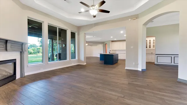 a view of an empty room with wooden floor and a fireplace