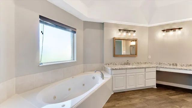 a bathroom with a tub sink and mirror
