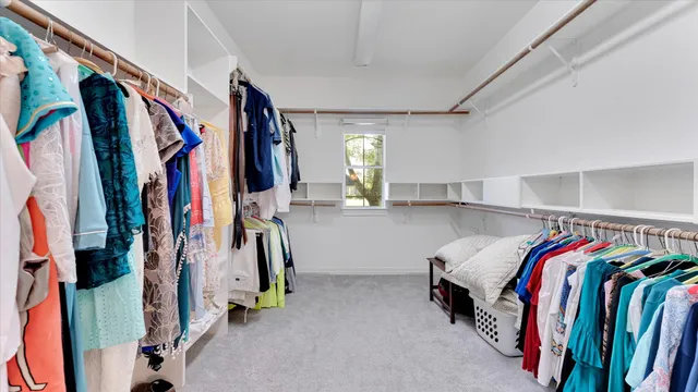 a view of walk in closet with clothes and shoes