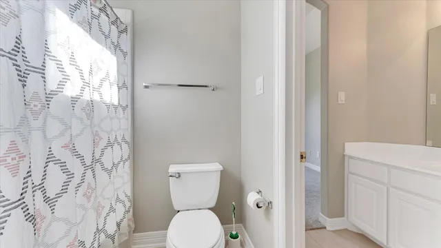 a bathroom with a toilet and a shower