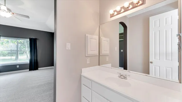 a bathroom with a tub sink and mirror
