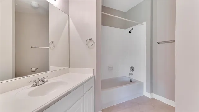 a bathroom with a tub shower sink and mirror