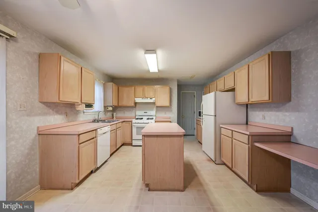 a kitchen with a sink cabinets stainless steel appliances and a window