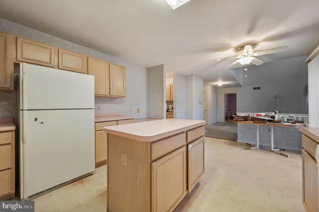 a view of a kitchen with a sink and dishwasher a refrigerator with white cabinets