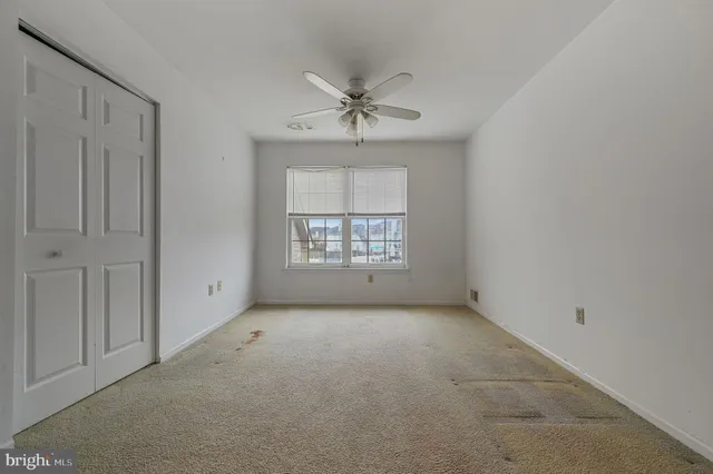 a view of a big room with windows and chandelier fan