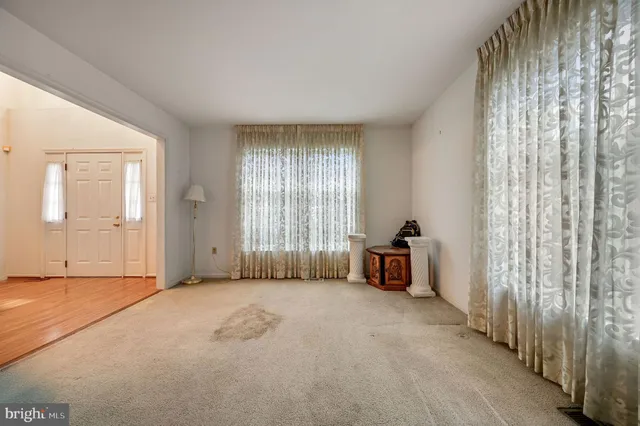 an empty room with windows and fireplace