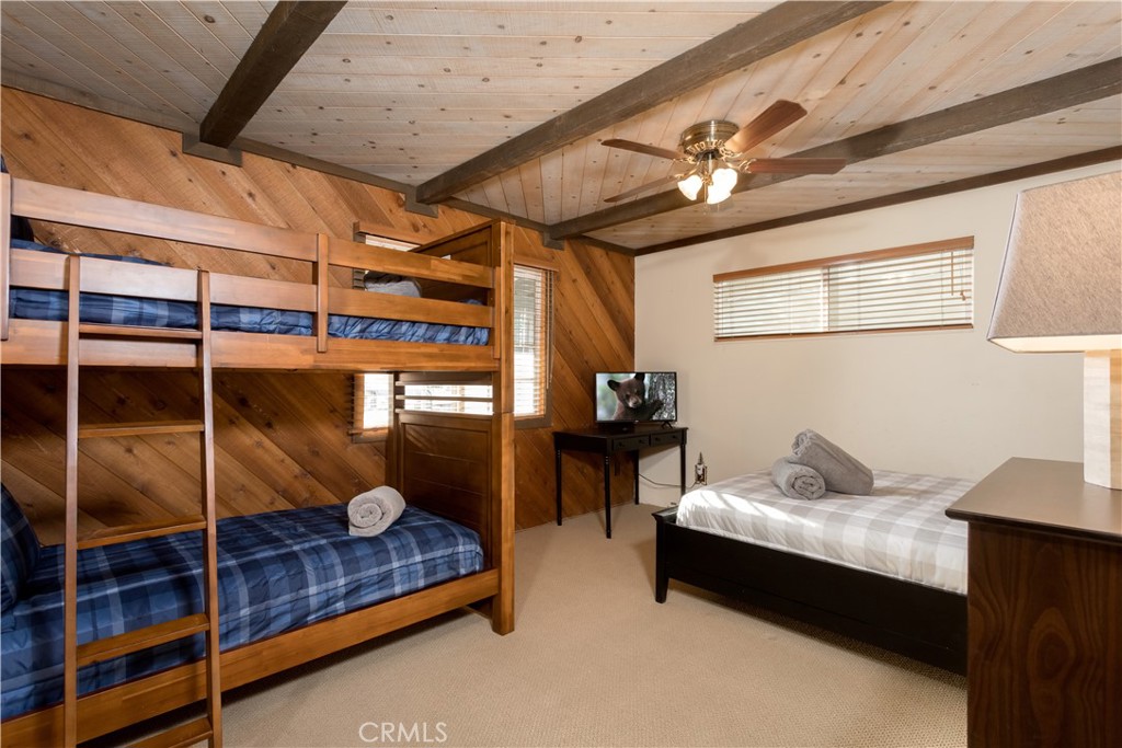 43014 Moonridge Road Big Bear Lake, CA 92315 - Photo 15 of 22 a bedroom with furniture and a chandelier