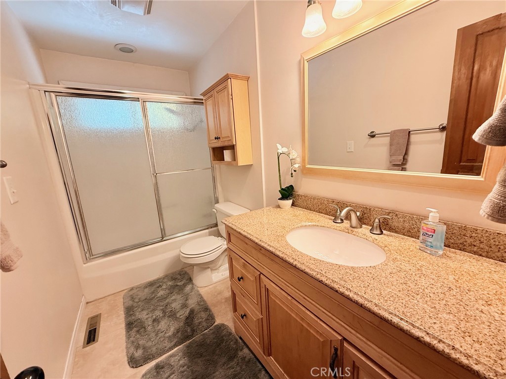 43014 Moonridge Road Big Bear Lake, CA 92315 - Photo 18 of 22 a bathroom with a granite countertop sink toilet and shower