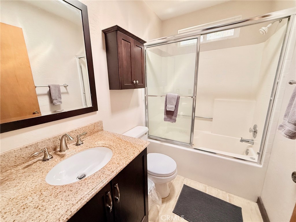 43014 Moonridge Road Big Bear Lake, CA 92315 - Photo 21 of 22 a bathroom with a granite countertop sink mirror vanity and toilet