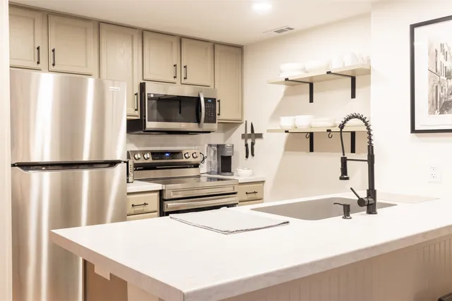 a kitchen with a refrigerator a stove and a sink