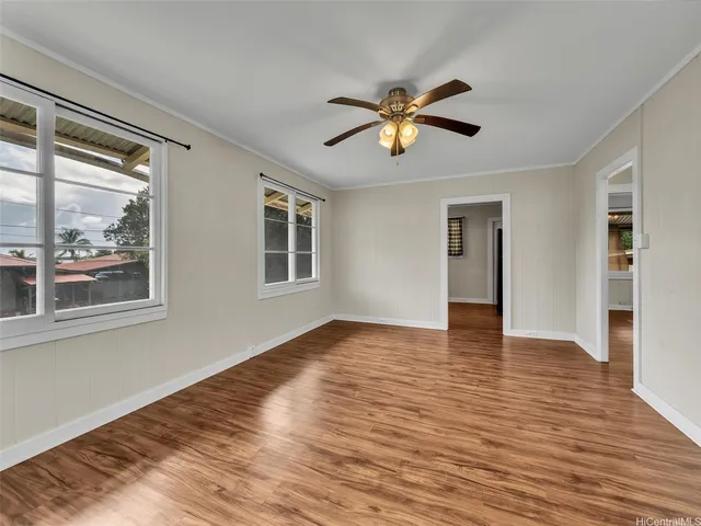 a view of empty room with wooden floor and window