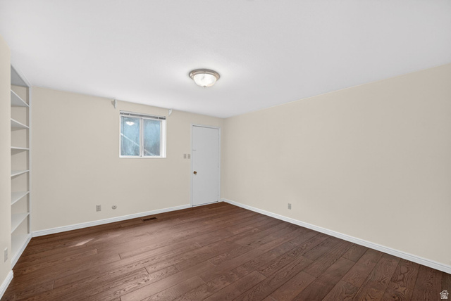 3120 North Apache Way Provo, UT 84604 - Photo 43 of 58 Spacious room featuring rich wood-finish flooring, light neutral walls, and a built-in shelving unit