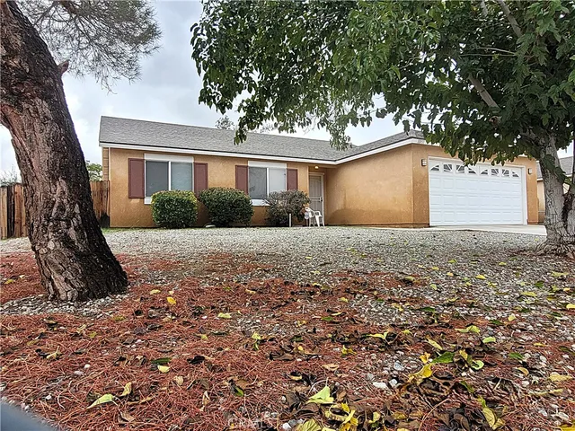 a front view of a house with a yard and trees
