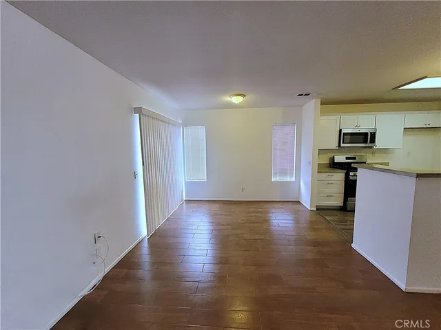 a view of a kitchen with a sink stove cabinets and empty room
